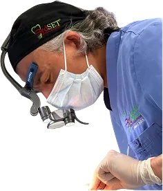 Dr. Athari performing a dental procedure while wearing his 3rdSET® surgical cap, loupes, and mask at Pleasant-Smiles in Henderson