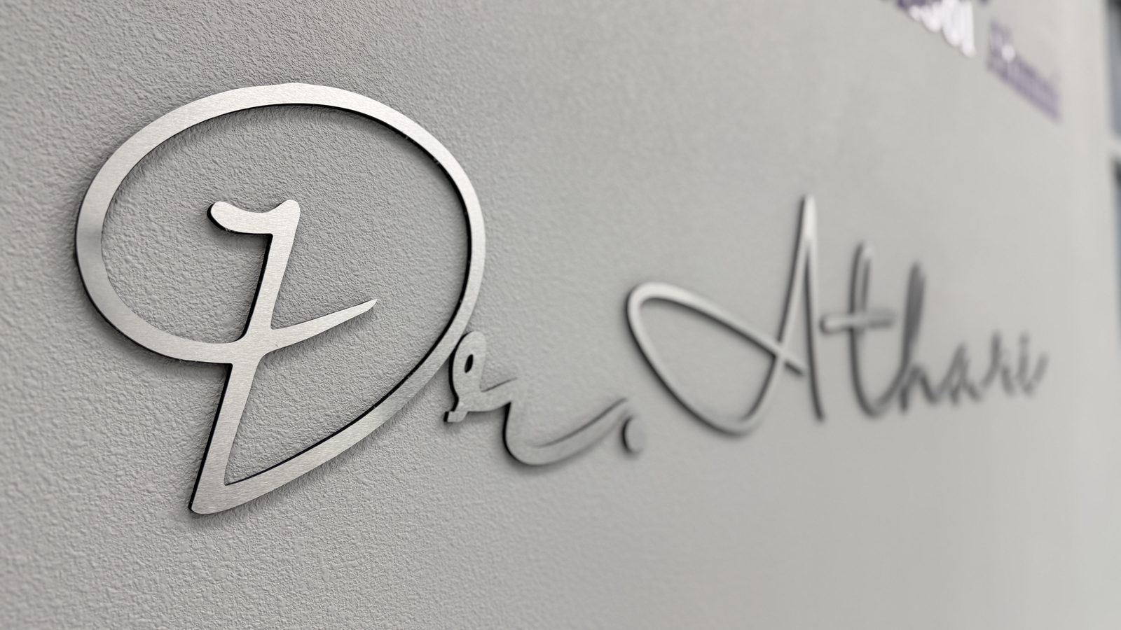 The Dr. Athari signature logo mounted on the wall at the Pleasant-Smiles practice in Henderson, NV
